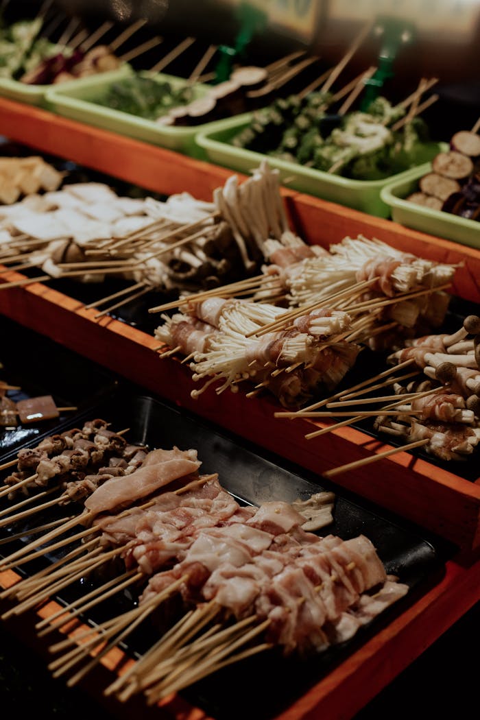 Delicious assortment of Asian street food skewers, featuring meats and vegetables in a vibrant market.